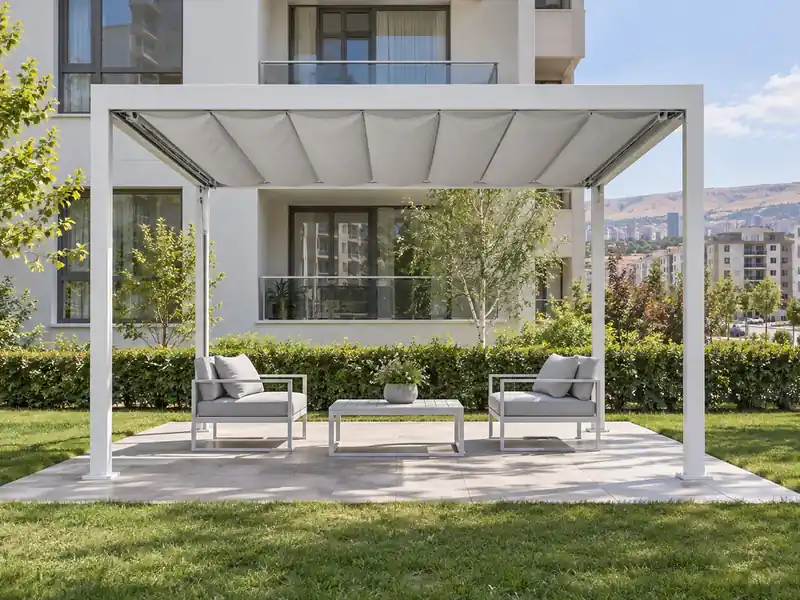 Bahçede dört alüminyum dikmeli, gri brandası açılmış motorlu pergola tente